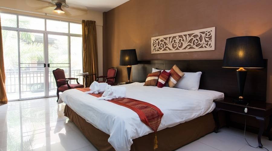 Modern hotel room with king-size bed and lamps.