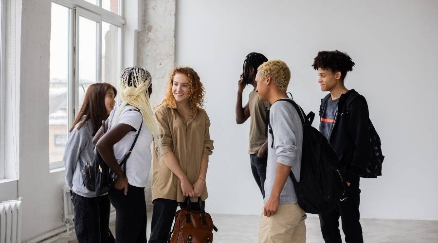Group of diverse students talking in classroom