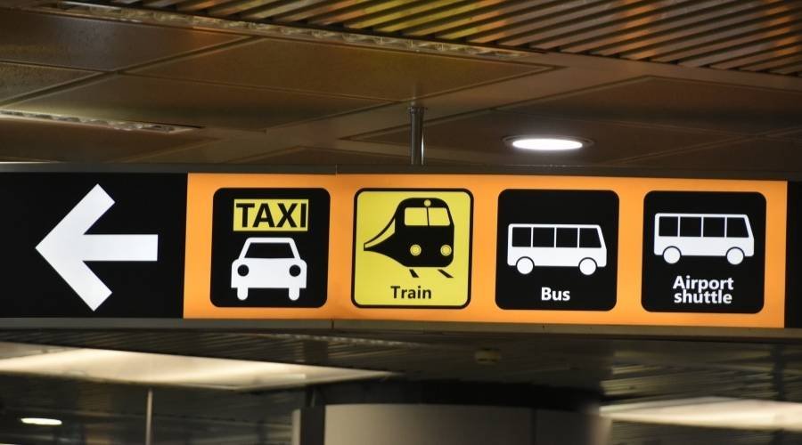 Airport transportation signs: taxi, train, bus, shuttle.