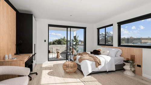 Modern bedroom with large windows and natural light.