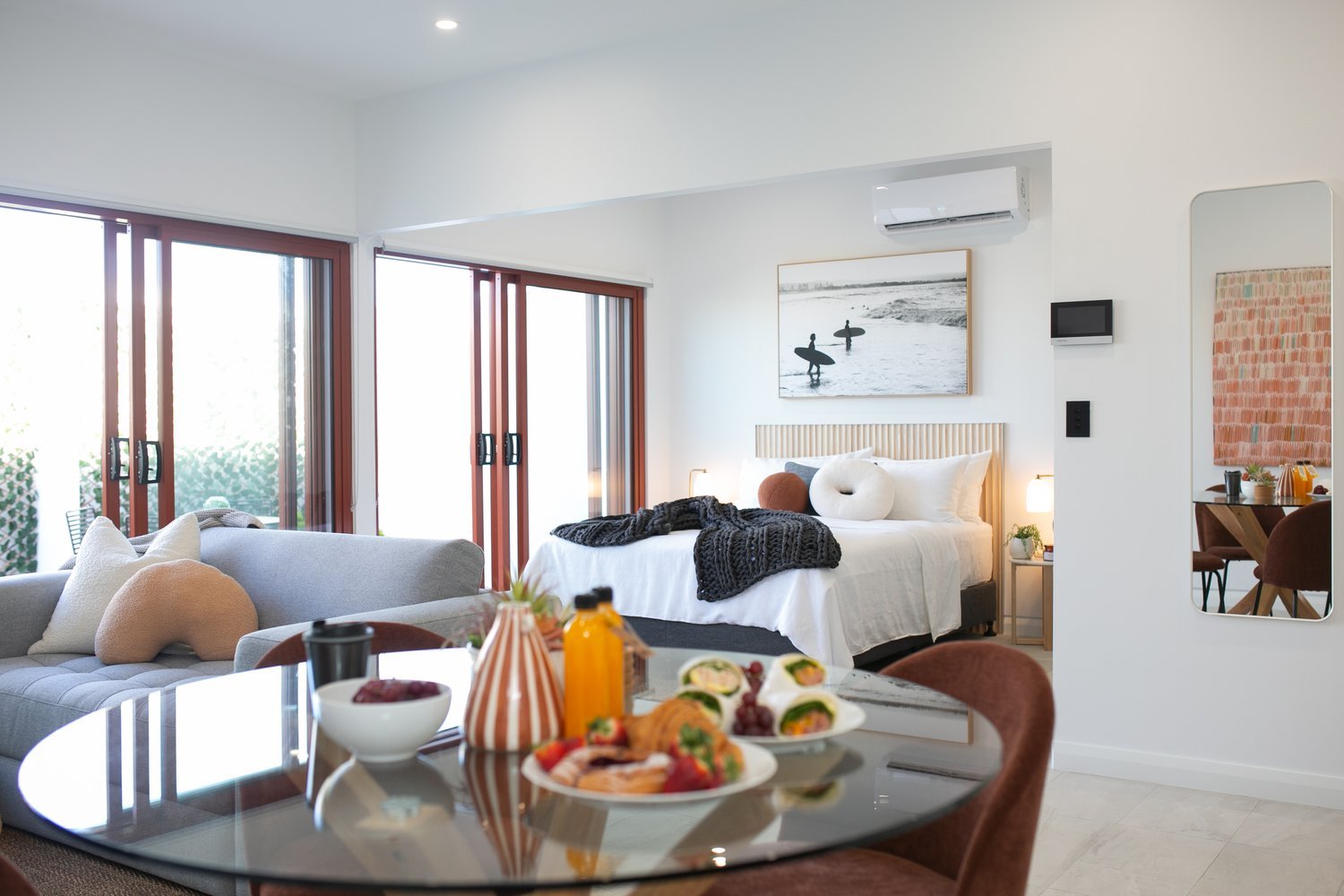 Modern bedroom with breakfast setup on table.