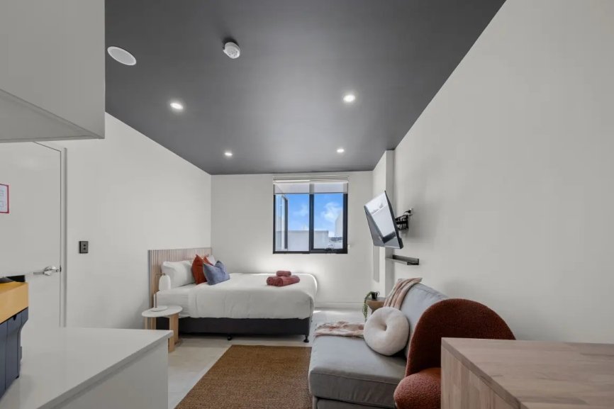 Modern minimalist bedroom with sofa and TV