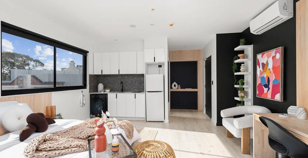 Modern studio apartment with kitchenette and decor.