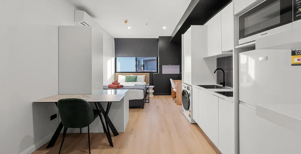 Modern studio apartment with kitchen and bed
