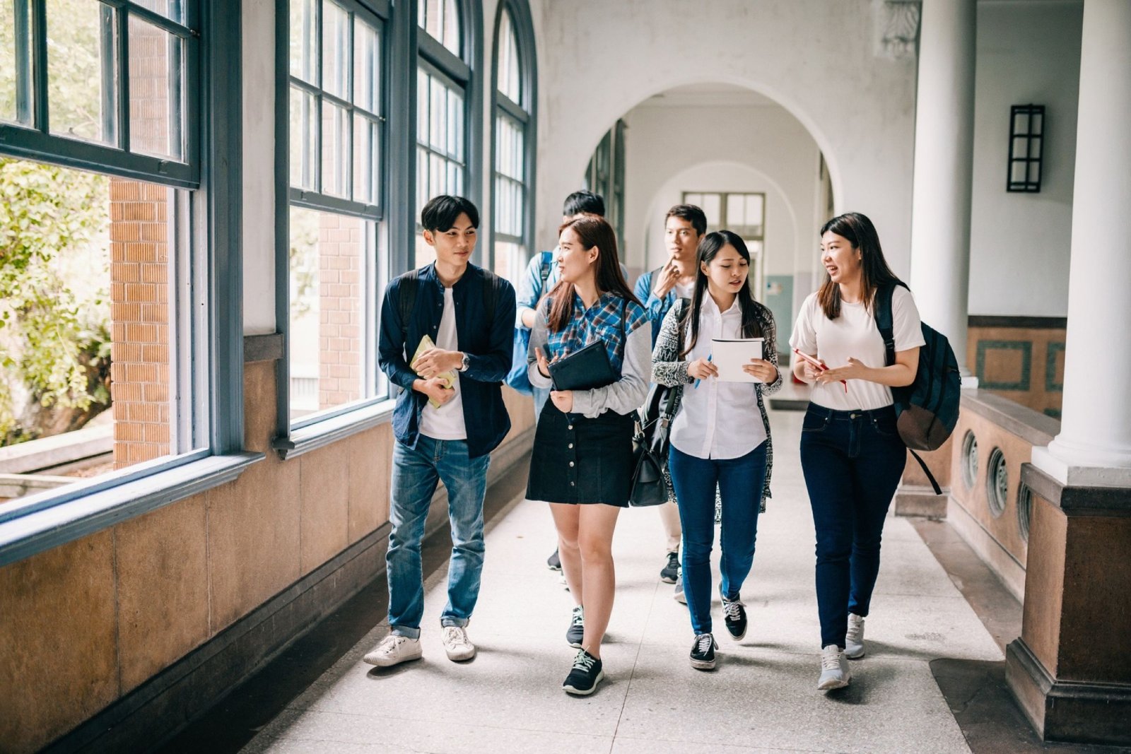 Group of students walking in school hallway.