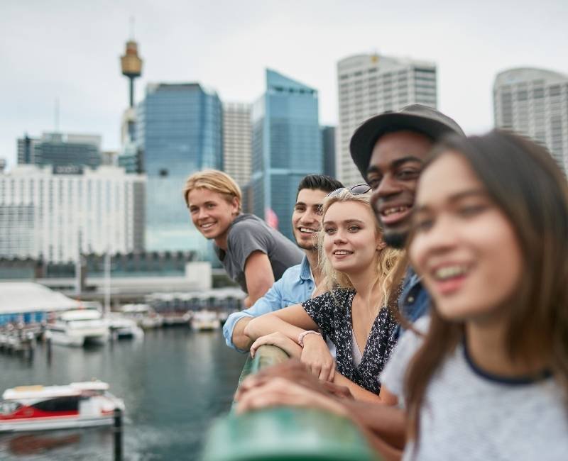 Group of friends smiling by city waterfront